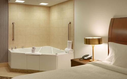桑迪盐湖城/沙蒂希尔顿花园酒店的带浴缸、床和电话的浴室