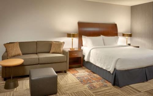 桑迪盐湖城/沙蒂希尔顿花园酒店的酒店客房,配有床和沙发