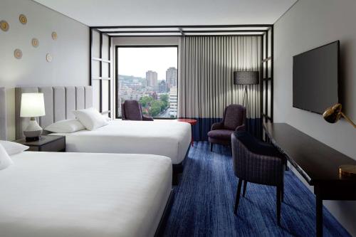 蒙特利尔DoubleTree By Hilton Montreal的酒店客房设有两张床和窗户。