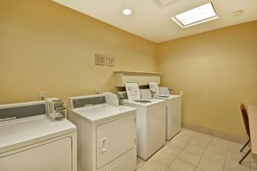 河头镇里弗黑德希尔顿花园旅馆的洗衣房配有3台洗衣机和烘干机