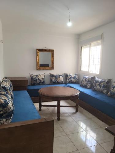 得土安Complexe tamuda doha tetouan的客厅配有蓝色的沙发和桌子