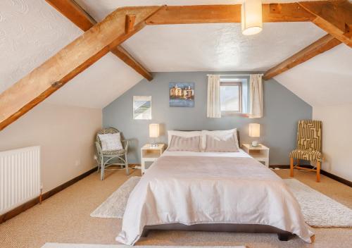 SwimbridgeDairy Cottage的阁楼上一间卧室配有一张床和两把椅子