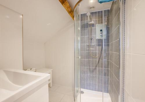 SwimbridgeDairy Cottage的带淋浴和盥洗盆的白色浴室