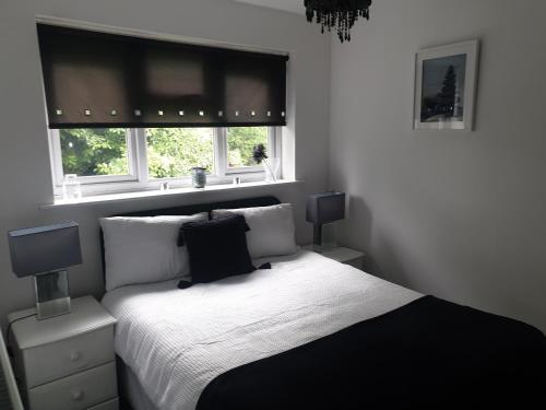 伍尔弗汉普顿A&S properties, no guest fees, with drive and near city centre的一间卧室设有黑白床和2个窗户。