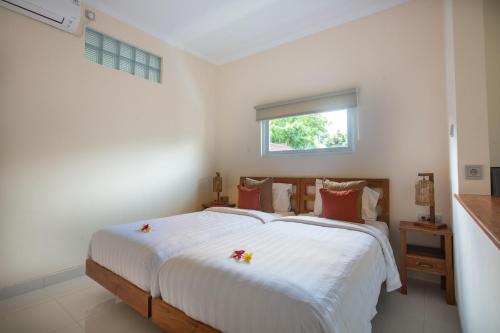 金巴兰Donguri House Bali的一间卧室配有一张带白色床单的床和一扇窗户。