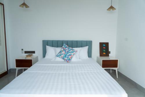 科伦坡Four Petals Inn的一间卧室配有白色床和2个床头柜