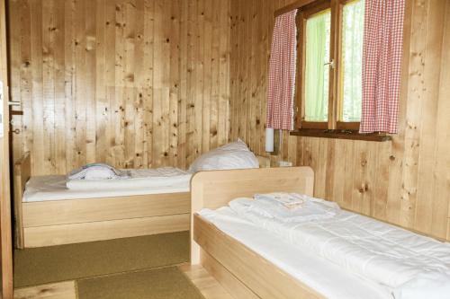 埃格Ferienhaus Schetteregg的木间设有两张床,设有窗户