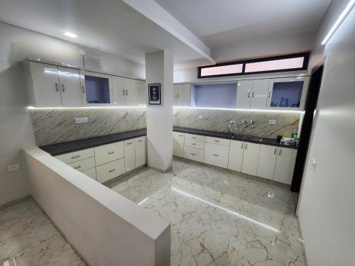 印多尔EL Dorado 11的一间铺有大理石地板并配有白色橱柜的大浴室