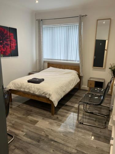 特伦特河畔斯托克Zams rooms的一间卧室设有一张床、一个窗口和一把椅子