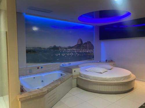 克里西玛Passione Criciúma - Adult Only的客房设有带大窗户的浴缸。
