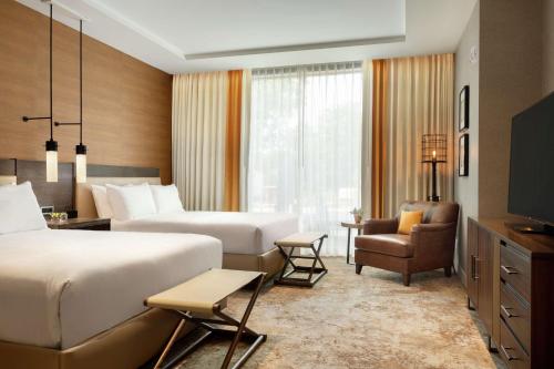 摩押Hoodoo Moab, Curio Collection by Hilton的酒店客房,配有两张床和椅子