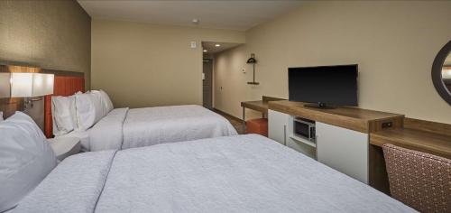 罗斯堡Hampton Inn & Suites Roseburg的酒店客房设有两张床和一台平面电视。