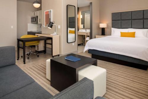 贝尔蒙Homewood Suites By Hilton Belmont的配有一张床和一张书桌的酒店客房