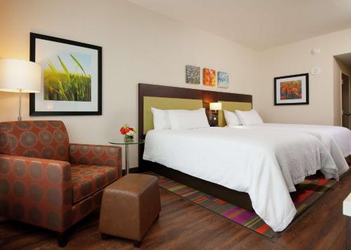 匹兹堡匹兹堡市中心希尔顿花园酒店的酒店客房带一张大床和一把椅子