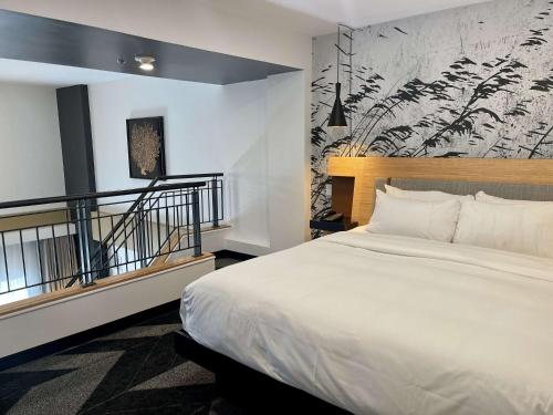 魁北克市DoubleTree by Hilton Quebec Resort的卧室设有一张白色大床和楼梯。