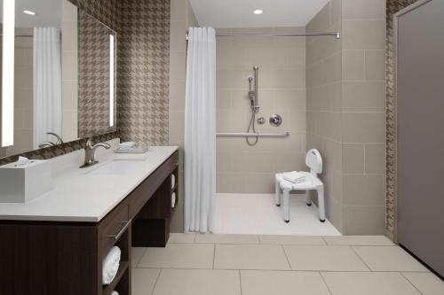 卡尔斯巴德Home2 Suites By Hilton Carlsbad New Mexico的带淋浴、盥洗盆和卫生间的浴室