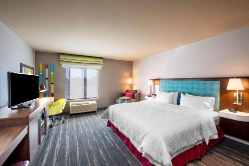 KellerHampton Inn & Suites Keller Town Center的配有一张床和一台平面电视的酒店客房