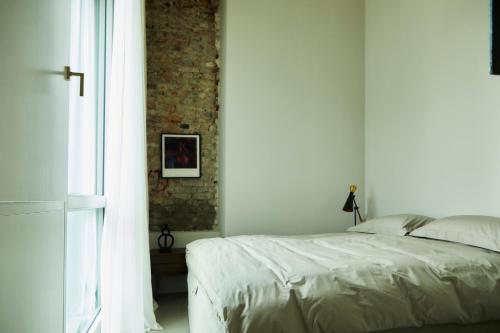 柏林Stadtflucht Loft 5.2.2的卧室配有白色的床和砖墙