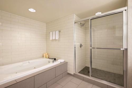 亚特兰大Embassy Suites by Hilton Atlanta at Centennial Olympic Park的白色的浴室设有浴缸和淋浴。