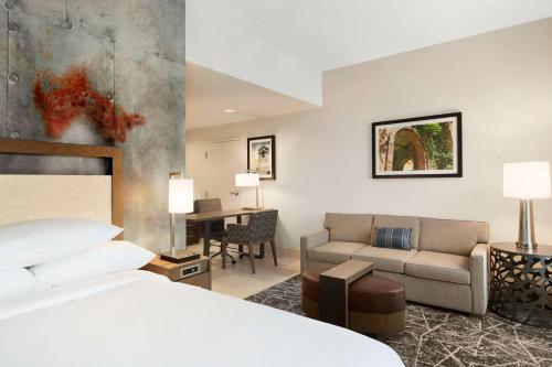 圣安东尼奥Embassy Suites San Antonio Brooks City Base Hotel & Spa的酒店客房,配有床和沙发