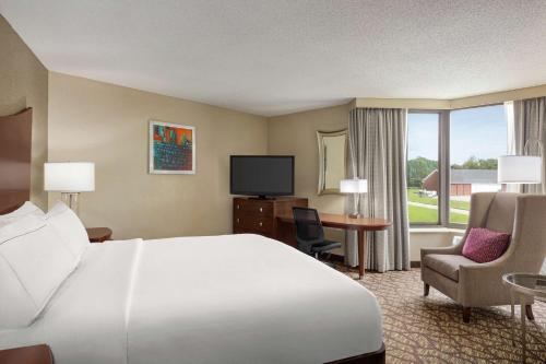 杰克逊杰克逊希尔顿逸林酒店的酒店客房设有一张床、一张书桌和一台电视机。