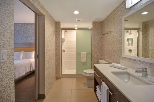 欧克莱尔Home2 Suites Eau Claire South, Wi的一间带水槽和卫生间的浴室以及一张床