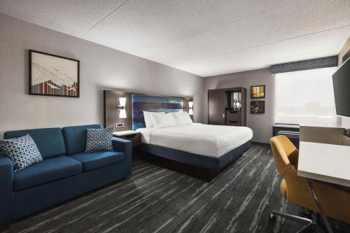 席勒公园芝加哥奥黑尔国际机场汉普顿酒店的酒店客房,配有床和沙发