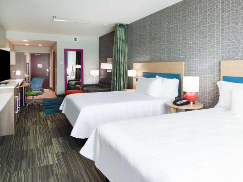 彭萨科拉Home2 Suites By Hilton Pensacola I-10 Pine Forest Road的酒店客房带两张床和一个客厅