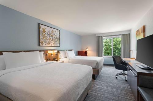 普莱恩维尤梅尔维尔希尔顿花园旅馆的酒店客房设有两张床和一台平面电视。