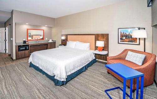 渥太华渥太华希尔顿汉普顿酒店 的配有一张床和一把椅子的酒店客房