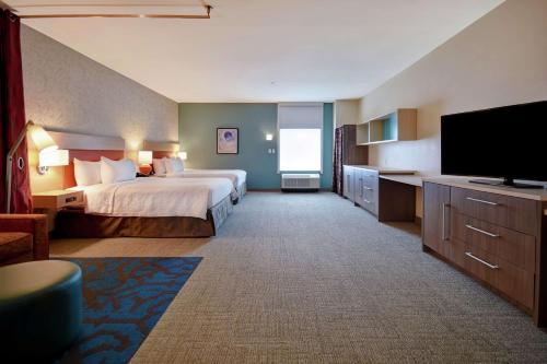 哈维Home2 Suites by Hilton Harvey New Orleans Westbank的配有一张床和一台平面电视的酒店客房