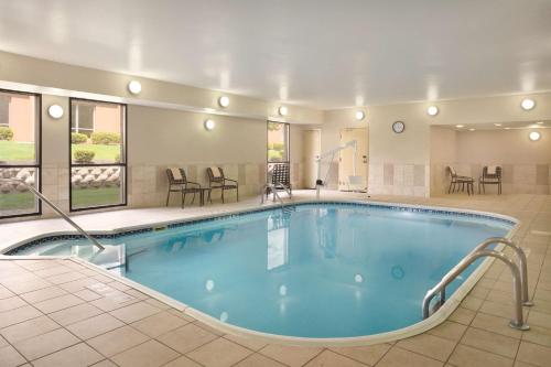 曼斯费尔德曼斯菲尔德/安大略希尔顿恒庭酒店的酒店的大型游泳池配有桌椅