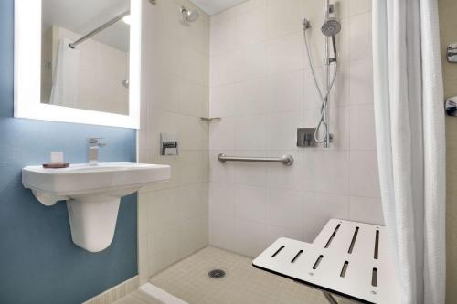 圣安东尼奥圣安东尼奥机场合博套房酒店的白色的浴室设有水槽和淋浴。
