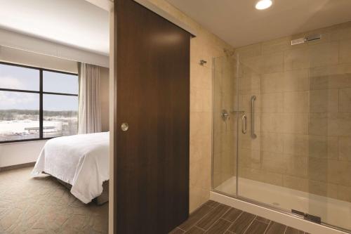 北坎顿阿克伦坎顿机场希尔顿尊盛酒店的带淋浴的浴室和1间带1张床的卧室