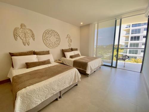 卡塔赫纳Apartamento de Lujo Morros Zóe - Manzanillo - Cartagena的酒店客房设有两张床和一个阳台。