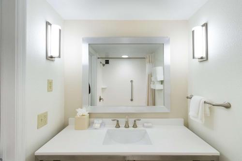 代托纳海滩代托纳比奇机场希尔顿花园酒店的白色的浴室设有水槽和镜子