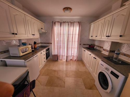 卡亚俄萨尔瓦赫Apartamento en Callao Salvaje的厨房配有白色橱柜、洗衣机和烘干机