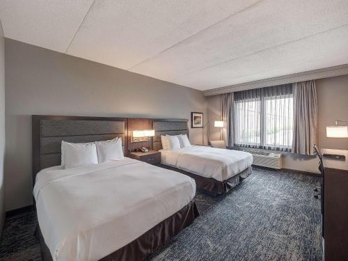 布卢明顿布卢明顿希尔顿逸林酒店的酒店客房设有两张床和窗户。