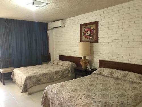 阿卡普尔科Hotel las hamacas的酒店客房,设有两张床和一盏灯