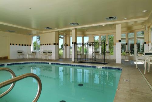 塔尔萨塔尔萨机场希尔顿花园酒店的大楼内带桌椅的大型游泳池