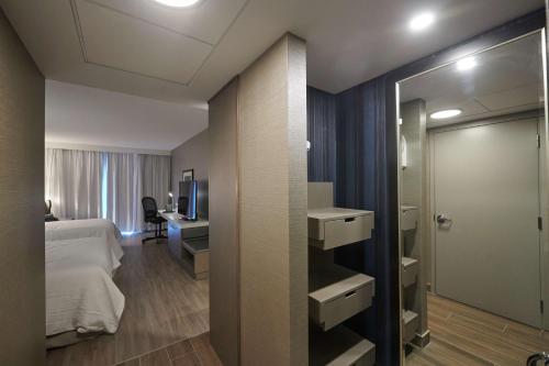 圣约翰斯Hilton Garden Inn St. John's Newfoundland, Canada的一间卧室配有一张床、一张书桌和一面镜子
