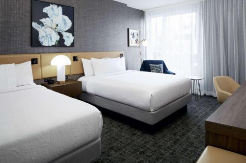 蒙特利尔Hilton Garden Inn Montreal Midtown, Quebec, Canada的酒店客房配有两张床和一张书桌