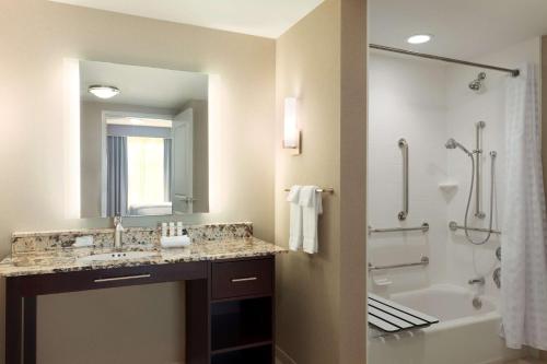 弗雷德里克弗雷德里克希尔顿惠庭套房酒店的一间带水槽、浴缸和淋浴的浴室