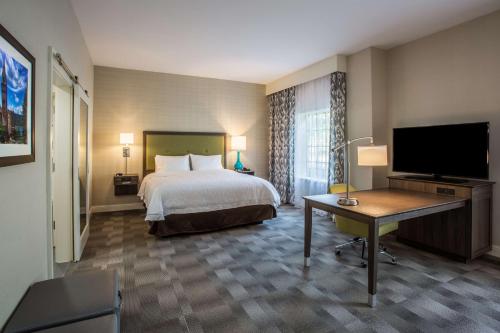 扬克斯扬克斯汉普顿酒店 - 威彻斯特的配有一张床和一台平面电视的酒店客房