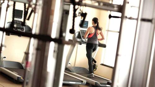 东拉瑟福德新泽西州梅多兰兹东拉瑟福德希尔顿惠庭套房酒店的一名在健身房跑步机上跑步的女人