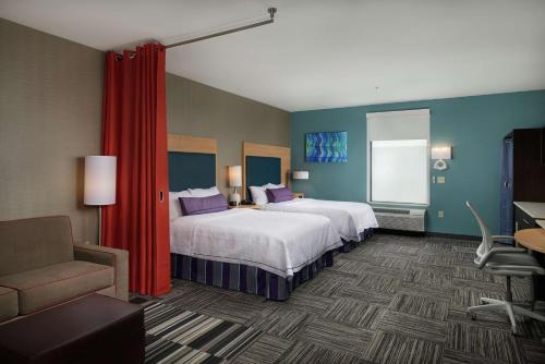 马斯科吉Home2 Suites By Hilton Muskogee的酒店客房,配有两张床和椅子