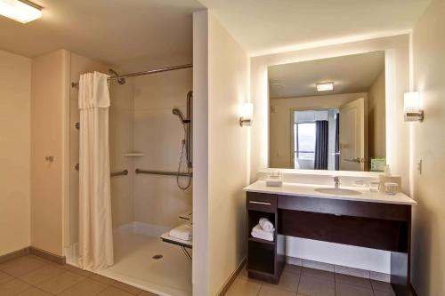 伊瑟阔西雅图伊萨夸希尔顿惠庭套房酒店的一间带水槽、淋浴和镜子的浴室