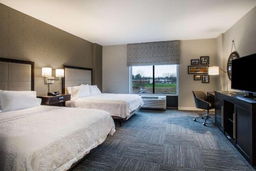 PenfieldHampton Inn Rochester Penfield, Ny的酒店客房设有两张床和一台平面电视。