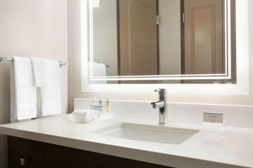 尔湾希尔顿惠庭欧文约翰韦恩机场套房酒店的浴室设有白色水槽和镜子