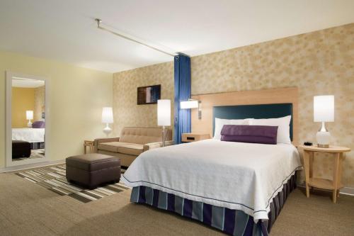 圣约翰堡圣约翰堡希尔顿欣庭套房酒店的酒店客房设有一张大床和一张沙发。